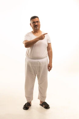 الاشارة باصبع السبابة نحو شيء ما ،النظر الى الكاميرا بايماءات الجدية والثقة بالنفس، بورتريه لرجل كبير السن عربي خليجي سعودي يرتدي سروال وفنيله ونظارات طبية ، الجسم بالطول الكامل، خلفية بيضاء