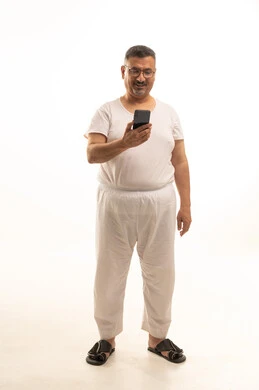 Browsing the internet via mobile, a modern and advanced technical device, accomplishing work tasks remotely, a portrait of an elderly Arab Saudi Gulf man wearing pants and a t-shirt and wearing glasses, using a mobile phone, full body, white background. Browsing the internet via mobile, a modern and advanced technical device, accomplishing work tasks remotely, a portrait of an elderly Arab Saudi Gulf man wearing pants and a t-shirt and wearing glasses, using a mobile phone, full body, white background.