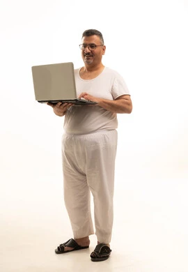 Browsing the internet, a modern and advanced technical device, accomplishing remote work tasks, a portrait of an elderly Arab Saudi Gulf man wearing pants and a t-shirt and wearing reading glasses using a laptop, full body, white background.