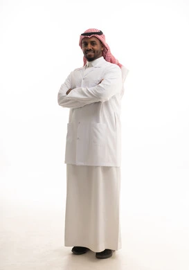مفهوم الطب والرعاية الصحية ،العمل في القطاع الصحي السعودي، إجراء الفحوصات اللازمة، بورتريه لطبيبب سعودي خليجي مبتسم يرتدي الشماغ والزي التقليدي والمعطف الابيض  يقدم خدماته للمرضى بكل كفاءه،  خلفية بيضاء