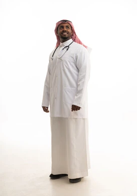 العمل في القطاع الصحي السعودي، إجراء الفحوصات اللازمة، مفهوم الطب والرعاية الصحية ، بورتريه لطبيبب سعودي خليجي مبتسم يرتدي الشماغ والزي التقليدي والمعطف الابيض  يقدم خدماته للمرضى بكل كفاءه،  خلفية بيضاء