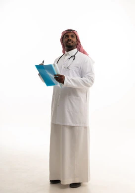 تدوين الملاحظات اللازمة ، كتابة التقارير الطبية ، مفهوم الطب والرعاية الصحية ، بورتريه لطبيبب سعودي خليجي مبتسم يرتدي الشماغ والزي التقليدي والمعطف الابيض ينظر للكاميرا يقدم خدماته للمرضى بكل كفاءه،  خلفية بيضاء