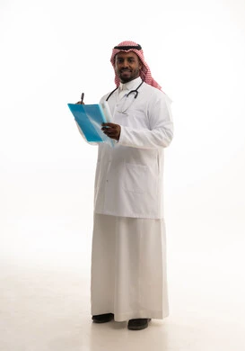 كتابة التقارير الطبية ، تدوين الملاحظات اللازمة ، مفهوم الطب والرعاية الصحية ، بورتريه لطبيبب سعودي خليجي مبتسم يرتدي الشماغ والزي التقليدي والمعطف الابيض ينظر للكاميرا يقدم خدماته للمرضى بكل كفاءه،  خلفية بيضاء