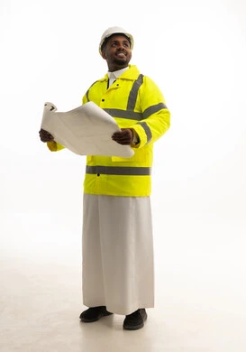 المتابعة والإشراف على العمل بشكل مباشر، الإعمار بسواعد أبناء الوطن، مفهوم الهندسة والانشاءات المعمارية، بورتريه لمهندس عربي خليجي سعودي يرتدي الثوب التقليدي والسترة الخاصة وخوذة الحماية يقف وبيده مخطط هندسي ، الجسم بالطول الكامل، خلفية بيضاء