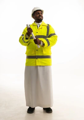 المتابعة والإشراف على العمل بشكل مباشر، الإعمار بسواعد أبناء الوطن، مفهوم الهندسة والانشاءات المعمارية، بورتريه لمهندس عربي خليجي سعودي يرتدي الثوب التقليدي والسترة الخاصة وخوذة الحماية يقف وبيده مخطط هندسي ، الجسم بالطول الكامل، خلفية بيضاء