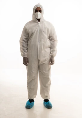 تجنب انتشار العدوى ، بورتريه لطبيب سعودي يرتدي معدات وقائية لمكافحة فيروس كورونا يرتدي رداء أبيض بلاستيكي قياسي و كمامة الوجه ينظر الى الكاميرا بتعابير الجدية،  خلفية بيضاء