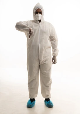 Expressions of rejection and disapproval, a portrait of a Saudi doctor wearing protective equipment to combat the coronavirus, dressed in a standard white plastic gown and face mask, looking at the camera with a serious expression, avoiding the spread of infection, white background.
