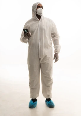 تجنب انتشار العدوى ،بورتريه لطبيب سعودي يرتدي معدات وقائية لمكافحة فيروس كورونا يرتدي رداء أبيض بلاستيكي قياسي و كمامة الوجه ، استخدام الهاتف المحمول ، التكنولوجيا والتقنيات الحديثة فى العمل ، خلفية بيضاء