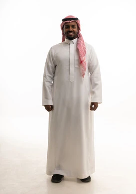 مفهوم الرجولة والقوة والثقة بالنفس، بورتريه لرجل عربي خليجي سعودي يرتدي الشماغ والزي التقليدي ينظر الى الكاميرا بإيماءات السرور والسعادة ، الاهتمام بالأناقة والمظهر الخارجي ، خلفية بيضاء