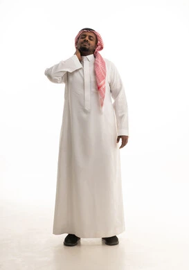 Joint and neck bone pain, the need for physical therapy, neck and spine pain, the feeling of fatigue and exhaustion, a portrait of a smiling Saudi Gulf Arab man wearing a ghutrah and traditional thobe, placing his hand around his neck in gestures of pain, full-body, white background.