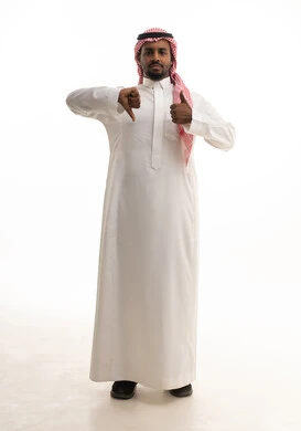 القلق والحيرة في اتخاذ القرار الصحيح، التفكير بعمق وشرود الذهن، محاولة إيجاد حل للمشكلات الصعبة، بورتريه لرجل عربي خليجي سعودي يرتدي الثوب التقليدي والشماغ  يشير بيده بإيماءات الحيرة، خلفية بيضاء