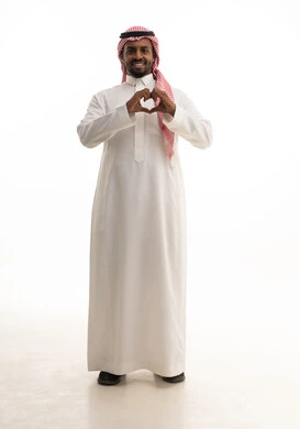 التعبير عن الاعجاب والمحبة، بورتريه لرجل عربي خليجي  سعودي يرتدي الثوب التقليدي والشماغ  يرفع يديه باشارة قلب الحب، إيماءات السعادة والسرور، صورة الجسم بالطول الكامل, خلفية بيضاء