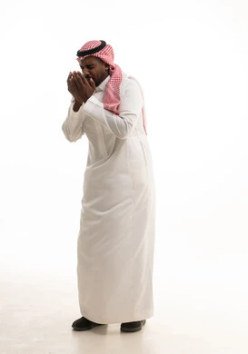طلب العون والرغبة في تحقيق الأمنيات, الوقوف بإيماءات الدعاء والتوسل والاسترحام, الطلب بترجي وتذلل من رب العباد, التضرع إلى الله تعالى, ،بورتريه لرجل عربي خليجي سعودي يرتدي الثوب التقليدي والشماغ  يرفع يديه بخشوع واستعطاف, خلفية بيضاء