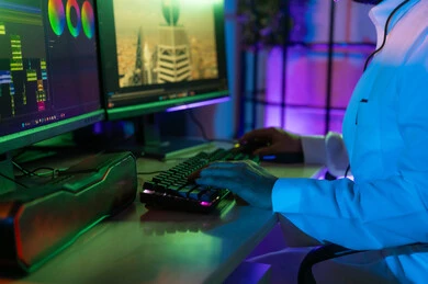 ايماءات الاندماج و التركيز، استخدام لوحة المفاتيح لتعديل الفيديوهات، صورة مقربة ليد مونتير عربي خليجي سعودي يعمل في غرفة المونتاج يستخدم الحاسب المحمول لقص وترتيب المشاهد، مفهوم صناعة المحتوى المرئي والإبداع الفني