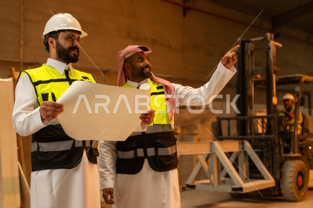 تبادل الآراء والخبرات، ورشات عمل في المملكة العربية السعودية, أدوات ومعدات مصنوعة من الرخام, جودة الانتاج المحلي الوطني, صناعة الأثاث المنزلي والمكتبي، رجل مهندس عربي خليجي سعودي يرتدي الثوب التقليدي وزي العمل يتناقش مع زميله
