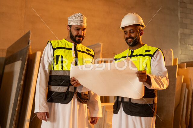 مبادلة الآراء والخبرات، ورشات عمل في سلطنة عمان, أدوات ومعدات مصنوعة من الرخام, جودة الانتاج المحلي الوطني, صناعة الأثاث المنزلي والمكتبي، رجل مهندس عربي خليجي عماني يرتدي الدشداشة وزي العمل يتناقش مع زميله