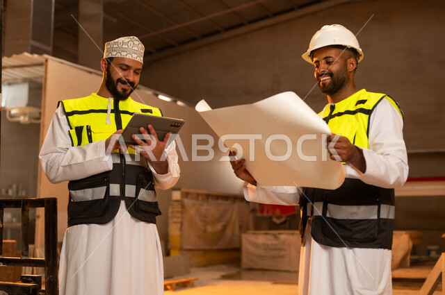مصانع ومعامل سلطنة عمان, أدوات ومعدات مصنوعة من الرخام، جودة الانتاج المحلي الوطني, صناعة الأثاث المنزلي والمكتبي، رجلان مهندسان عربيان خليجيان عمانيان يرتديان الدشداشة وزي العمل يعملان على جهاز التابلت، دمج التقنية والتكنولوجيا في المعامل