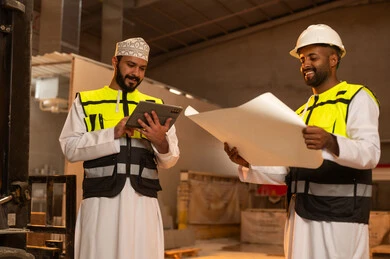 مصانع ومعامل سلطنة عمان, أدوات ومعدات مصنوعة من الرخام، جودة الانتاج المحلي الوطني, صناعة الأثاث المنزلي والمكتبي، رجلان مهندسان عربيان خليجيان عمانيان يرتديان الدشداشة وزي العمل يعملان على جهاز التابلت، دمج التقنية والتكنولوجيا في المعامل