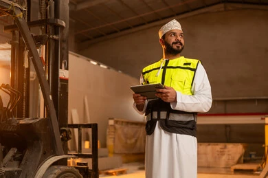 Integrating technology and technology in laboratories, workshops in the Sultanate of Oman, tools and equipment made of marble, quality of local national production, home and office furniture manufacturing, an Arab Gulf Omani engineer man wearing a dishdasha and work clothes holding a tablet in his hand