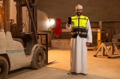 عرض شاشة سوداء فارغة على الهاتف المحمول، ورشات عمل في سلطنة عمان, أدوات ومعدات مصنوعة من الرخام، جودة الانتاج المحلي الوطني, صناعة الأثاث المنزلي والمكتبي، رجل مهندس عربي خليجي عماني يرتدي الدشداشة وزي العمل يمسك بيده الجوال