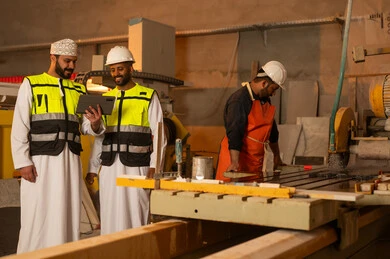 مراقبة أداء العامل وتقيمه عبر التابلت، مصانع ومعامل سلطنة عمان, ألات ومكنات لصناعة الرخام، جودة الانتاج المحلي الوطني, رجلان مهندسان عربيان خليجيان عمانيان يرتديان الدشداشة وزي العمل يعملان على الجهاز اللوحي، دمج التقنية والتكنولوجيا في المعامل