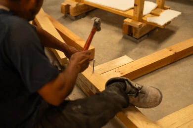 حرف ومهن عربية سعودية تقليدية قديمة، ورشة ومصنع عمل، استخدام ادوات و معدات النجارة، صورة مقربة لحرفي عربي خليجي سعودي يقوم باستخدام المطرقة والمسمار على قطعة الخشب في منجرة