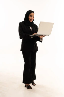 مشاهدة فيديوهات عبر الحاسب المحمول, استخدام الأجهزة التقنية الحديثة في الحياة اليومية, بورتريه لامرأة عربية سعودية خليجية محجبة مبتسمة ترتدي البدلة الرسمية السوداء تقف باستقامة و تحمل بيدها جهاز اللابتوب, خلفية بيضاء