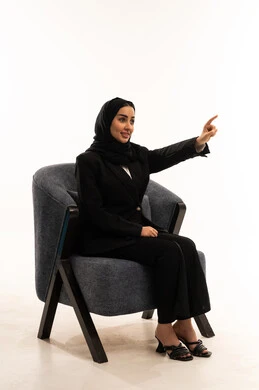 Pointing at something, attention to beauty and elegance, gestures of happiness and joy, concern for style and outward appearance, portrait of a young Arab Gulf Saudi woman with black hair and raising her index finger to choose, white background