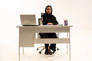 عرض شاشة سوداء فارغة على الهاتف المحمول، وظيفة نسائية مكتبية سعودية، ادارة وانجاز المهام باستخدام جهاز تقني حديث ومتطور, بورتريه لامرأة عربية سعودية خليجية محجبة ترتدي البدلة الرسمية السوداء تستخدم اللابتوب و الموبايل, خلفية بيضاء