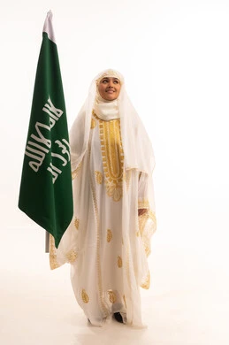 يوم العلم السعودي11 مارس، يوم بدينا 1727 م، ارتداء أزياء المنطقة الشرقية، بورتريه لإمرأة عربية خليجية سعودية مبتسمة ترتدي الشيلة والنشل تحمل بيدها علم يوم تأسيس الدولة السعودية الأولى، الاحتفال بالأعياد الوطنية الشعبية، الجسم بالطول الكامل، خلفية بيضاء