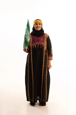Pride in historical heritage, Flag Day March 11, the day we started in 1727 AD, wearing the Central Region costume, Saudi National Day September 23, portrait of a Saudi Arabian Gulf woman wearing a kurta and a head holding the Kingdom's flag looking at the camera with an expression of pride, full body, white background