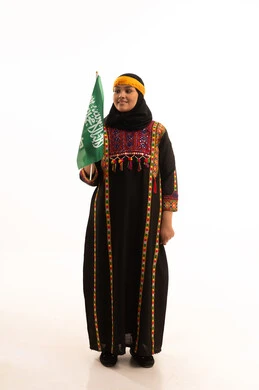 Pride and boasting of the country's achievements, pride in historical heritage, Flag Day March 11, the day we started in 1727 AD, wearing the Central Region costume, Saudi National Day September 23, portrait of a Saudi Arabian Gulf woman wearing a kurta and a head holding the Kingdom's flag, full-length body, white background