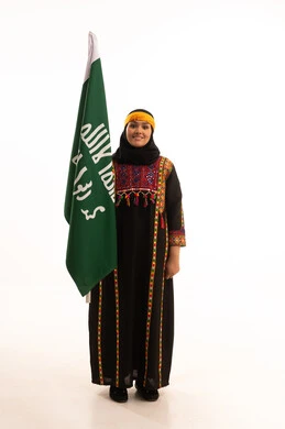 Anniversary of the founding of the first Saudi state, February 22, the day of our beginnings, 1727 AD, wearing the costumes of the central region, a portrait of a smiling Saudi Arabian Gulf woman wearing a kurta and a hat, holding the Founding Day flag in her hand, celebrating popular national occasions and holidays, full-length body, white background