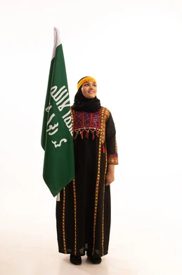 Anniversary of the founding of the first Saudi state, February 22, the day of our beginnings, 1727 AD, wearing the costumes of the central region, a portrait of a smiling Saudi Arabian Gulf woman wearing a kurta and a hat, holding the Founding Day flag in her hand, celebrating popular national occasions and holidays, full-length body, white background