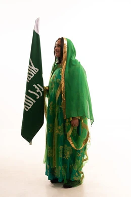 Standing up straight and raising the founding flag with expressions of pride and boasting, gestures of joy and happiness, the anniversary of the founding of the first Saudi state, February 22, a portrait of a Saudi Arabian Gulf woman wearing a shayla and a bisht, celebrating Badina Day 1727 AD, a full body photo, a white background