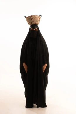 Traditional crafts and folk works, celebrating Badina Day 1727 AD, women's handicrafts, the anniversary of the founding of the first Saudi state, February 22, portrait of a Saudi Arabian Gulf woman wearing a burqa and black abaya, with a straw basket on her head, full body image, white background