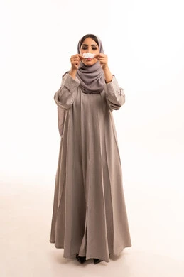 التخلص من الرؤوس السوداء والجلد الميت،بورتريه لامرأة عربية خليجية سعودية ترتدي الحجاب و العباءة تقوم بوضع لصقات الأنف، استخدام ماسكات تنظيف المسام ومكونات تجميلية ، العناية والاهتمام بنضارة وتحسين البشرة، الجسم بالطول الكامل، خلفية بيضاء