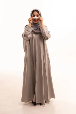 Getting rid of blackheads and dead skin, a portrait of a Saudi Arabian Gulf woman wearing a hijab and abaya applying nose strips, using pore cleansing masks and cosmetic ingredients, caring for and focusing on skin freshness and improvement, full-body shot, white background.