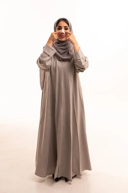 استخدام ماسكات تنظيف المسام ومكونات تجميلية ، التخلص من الرؤوس السوداء والجلد الميت،بورتريه لامرأة عربية خليجية سعودية ترتدي الحجاب و العباءة تقوم بوضع لصقات الأنف، العناية والاهتمام بنضارة وتحسين البشرة، الجسم بالطول الكامل، خلفية بيضاء