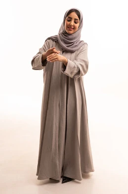 روتين العناية بالبشرة ، ترطيب وتنظيف وتفتيح الجلد، مفهوم الإهتمام بنضارة وتحسين البشرة، استخدام مكونات تجميلية شبابية، بورتريه لامرأة عربية خليجية سعودية ترتدي الحجاب و العباءة تضع كريم المرطب على يديها، الجسم بالطول الكامل، خلفية بيضاء