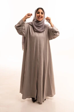 روتين نظافة الفم اليومية، تجنب التسوس وأمراض اللثة، التأكد من نظافة الأسنان بعد تناول الطعام, بورتريه لامرأة عربية خليجية سعودية ترتدي الحجاب و العباءة تقوم باستعمال الخيط السني، النظر الى الكاميرا بإيماءات السعادة والسرور, الجسم بالطول الكامل، خلفية بيضاء