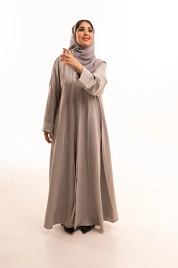 التطيب والتعطر بالعود والزيوت العطرية, مفهوم الأناقة والإهتمام بالمظهر الخارجي, بورتريه لامرأة عربية خليجية سعودية ترتدي الحجاب و العباءة تقوم برش العطر, التسويق لمنتجات العطور والمستحضرات النسائية, الجسم بالطول الكامل، خلفية بيضاء