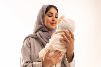 ايماءات الحب والعطف على الصغار, حنان الأمهات و تحمل المسؤولية والعناية بالأطفال, بورتريه مقرب لإمرأة عربيه خليجيه سعوديه ترتدي العباءة و الحجاب تحمل طفلتها بحب وحنان، خلفية بيضاء