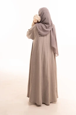 مساعدة الأطفال على النوم والهدوء النفسي، اهتمام الأمهات بالأطفال ورعايتهم, بورتريه من الخلف لإمرأة عربيه خليجيه سعوديه ترتدي العباءة و الحجاب تحمل طفلتها بحب وحنان, الجسم بالطول الكامل، خلفية بيضاء