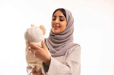 The feeling of the girl of comfort and calmness with her mother, a close portrait of an Arab Gulf Saudi woman wearing an abaya and hijab gently holding her daughter, the care of mothers for their children, the role of the mother in raising and nurturing children, the concept of motherhood and childhood, white background. The feeling of the girl of comfort and calmness with her mother, a close portrait of an Arab Gulf Saudi woman wearing an abaya and hijab gently holding her daughter, the care of mothers for their children, the role of the mother in raising and nurturing children, the concept of motherhood and childhood, white background.