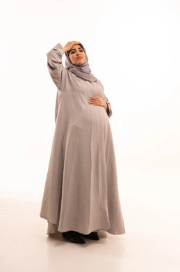 الاحساس بألم الرأس والصداع، الحاجة إلى العلاج والمساعده، المعاناة من آلام الشقيقة، الحاجة للهدوء والراحة، بورترية لامراه عربيه خليجيه سعودية حامل ترتدي العباءة و الحجاب تضع يديها على رأسها بايماءات التعب والارهاق، الجسم بالطول الكامل، خلفية بيضاء