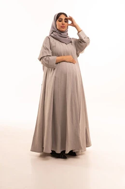 الصداع وألم الرأس، المعاناة من آلام الشقيقة، الحاجة للهدوء والراحة، بورترية لامراه عربيه خليجيه سعودية حامل ترتدي العباءة و الحجاب تضع يديها على رأسها بايماءات التعب والارهاق، الجسم بالطول الكامل، خلفية بيضاء