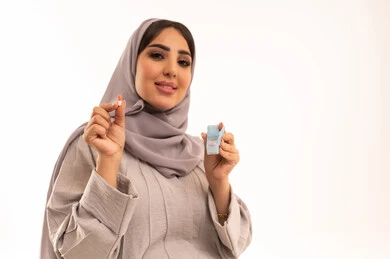 الاهتمام بالصحة والالتزام بالأوقات الصحيحة لأخذ العلاج، استخدام عقار الدواء بوصفة طبية, بورترية مقرب لامراه عربيه خليجيه سعودية حامل ترتدي العباءة و الحجاب تحمل شريط الدواء, مفهوم الطب والرعاية الطبية، خلفية بيضاء