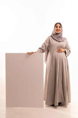 White rectangular mockup, marketing offers and advertisements, portrait of a Saudi Arabian Gulf woman wearing an abaya and hijab holding a blank rectangular white board in her hands, illustrative boards and educational tools, full body, white background.