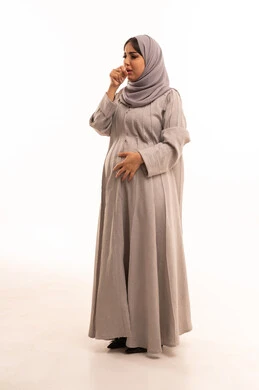 الإصابة بفايروس كورونا كوفيد19، الكحة والتهاب الحلق والحاجة للعلاج، الإصابة بالأنفلونزا ونزلات البرد, إيماءات الإرهاق والتعب الشديد، بورتريه لامرأة عربية خليجية سعودية حامل ترتدي العباءة و الحجاب تضع يدها أمام فمها وتقوم بالسعال, صورة الجسم بالكامل، خلفية بيضاء